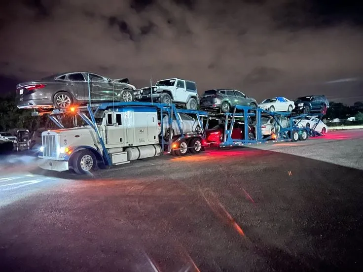 Cars loaded on an open two-level auto-transport trailer